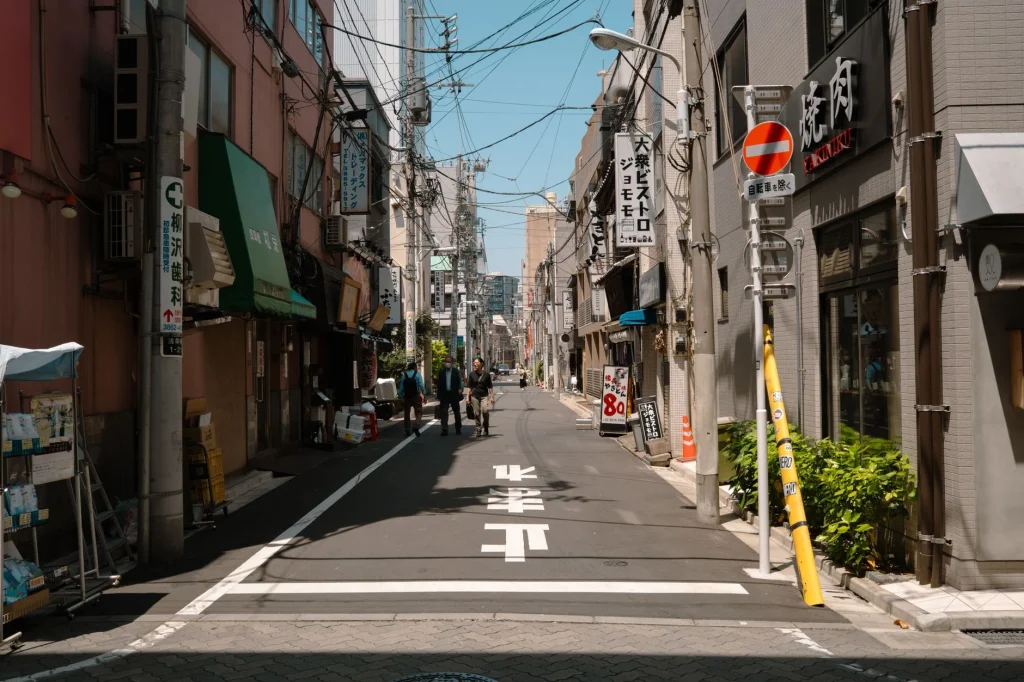Una calle tranquila de Tokio, que muestra la vida urbana y la arquitectura tradicional en un día soleado.